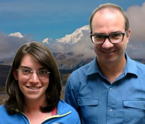 Lily and Bo smile at the camera in front of a photoshopped background of a mountain.