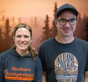 Jessie wears a "Northern Ecohydrology" sweatshirt, and Bob wears a "Kluane Chilkat International Bike Relay" T-shirt.
