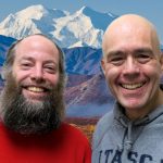 Jim and Eric smile in front of a Denali.