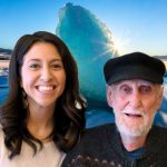 Krista and Dietrich, a young woman and an older man smile in front of a blue ice berg background.