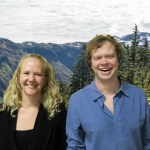 Davin and Tina smile at the camera in front of a photoshopped background of a forested landscape.